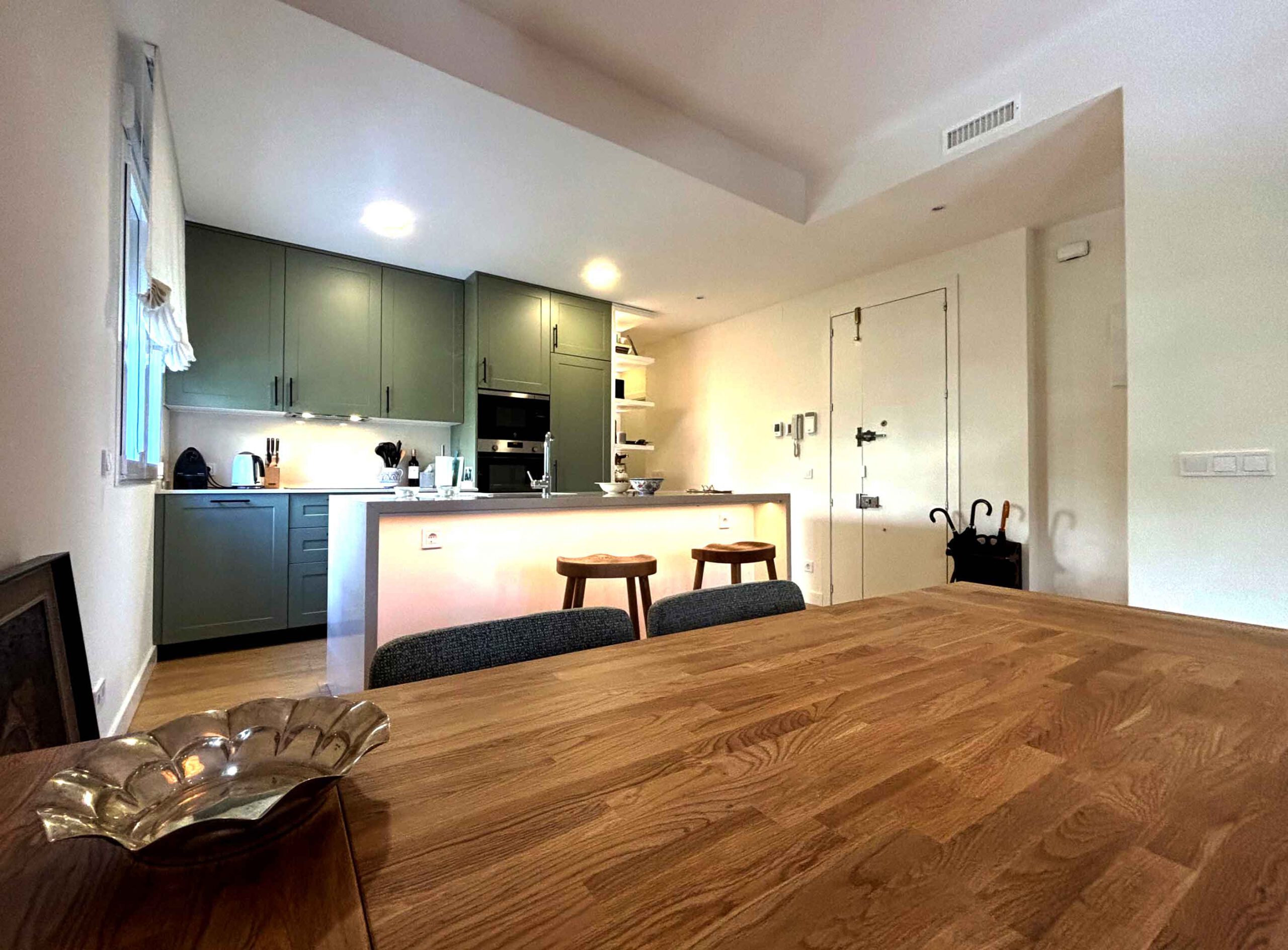 Salón comedor con cocina integrada de diseño moderno en vivienda reformada.